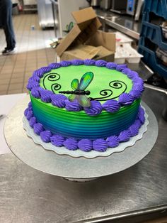 a green and purple cake sitting on top of a counter