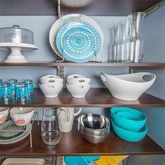 the shelves are filled with dishes, cups and other kitchen ware on it's sides