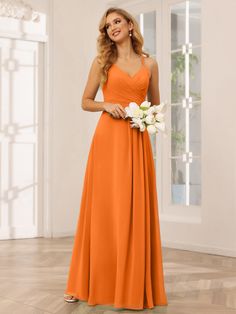 a woman in an orange bridesmaid dress standing on a wooden floor with flowers