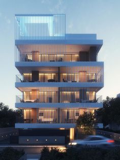 an apartment building with balconies lit up at night in front of the street