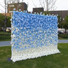 a large blue and white flowered display in the grass