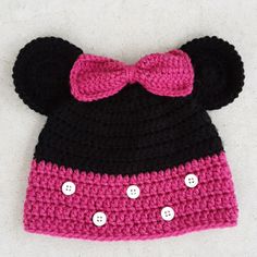 a crocheted minnie mouse hat with a pink bow on the front and black ears