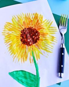 a drawing of a yellow flower with green leaves on it next to a knife and fork