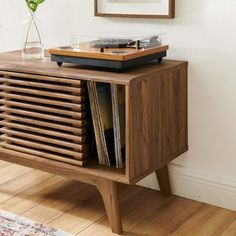 a record player sitting on top of a wooden cabinet