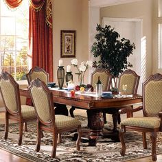 a dining room table with chairs and a potted plant in the middle of it