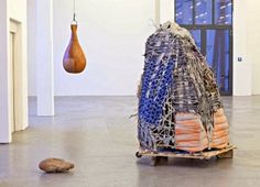 a sculpture is being pulled by a wooden object in the middle of an empty room