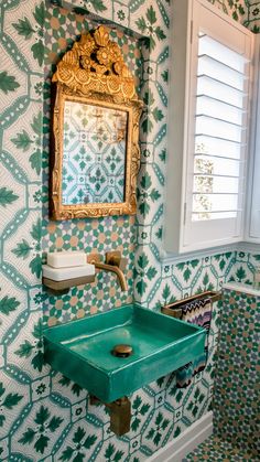 a green sink sitting under a mirror in a bathroom