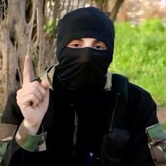 a person wearing a black mask and giving the peace sign