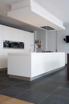 an empty kitchen with white cabinets and counter tops