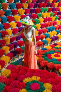 a woman is standing in front of many colorful flowers