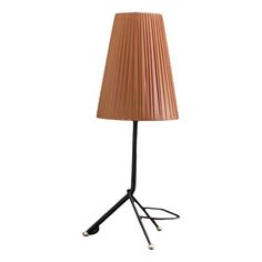 a lamp that is on top of a tripod with a light shade over it