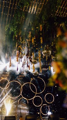 the olympic rings are lit up in front of fireworks and lights on stage at an event