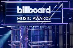 the billboard for music awards is shown in front of blue lights and birdcages