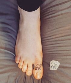 a person's foot with an elephant tattoo on the bottom of their left foot