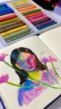 a drawing of a girl with flowers in front of colored crayons on a table