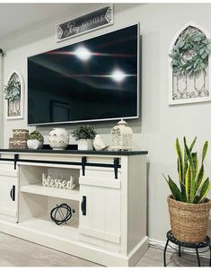 a flat screen tv mounted to the side of a white wall in a living room