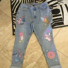 a pair of children's jeans with cartoon characters on them, sitting on the floor