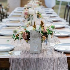 the table is set with white plates and silverware