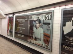 a subway station with posters on the wall