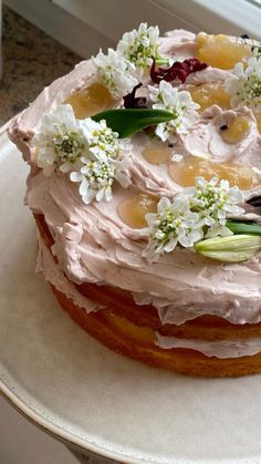 a cake with frosting and flowers is on a plate