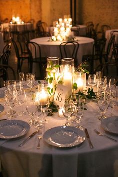 the table is set with candles and place settings for guests to sit down at it