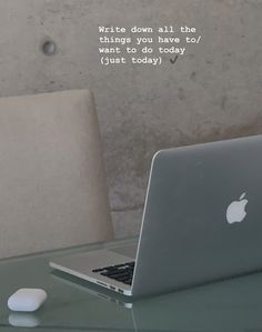 an apple laptop sitting on top of a glass table next to a mouse and keyboard