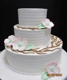 a three layer white cake with flowers on top