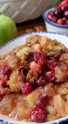 A serving of apple cranberry cobbler in a white bowl with a bowl of cranberries in the background. Sugar Crusted Apple Cobbler King Arthur, Cranberry Apple Casserole Recipes, Cranberry Cobbler Easy, Green Apple Cobbler, Apple Cherry Cobbler, Cranberry Apple Cobbler, Apple Cranberry Cobbler, Christmas Cobbler Recipes, Christmas Cobbler