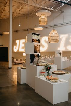 the interior of a restaurant with food displayed on pedestals and lights hanging from the ceiling