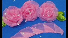 three pink roses are sitting on a blue surface with stars and green leaves around them