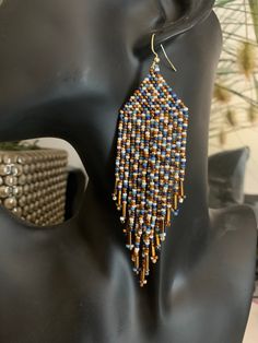 Beaded Fringe Earrings. Multi coloured in shades of blue, bronze, off white, brown and gold. Gold Artisan Beaded Earrings With Dangling Beads, Bronze Beaded Drop Earrings, Brown Copper Beaded Earrings, Unique Beaded Bronze Earrings, Handmade Bronze Beaded Earrings With Round Beads, Elegant Beaded Earrings With Colorful Beads, Handmade Bronze Beaded Earrings, Copper Beaded Round Earrings, Artisan Brown Earrings With Colorful Beads