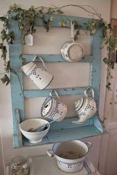 tea cups and saucers are displayed on an old window frame