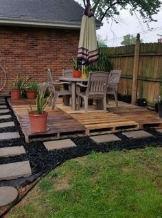 a patio with chairs, table and umbrella