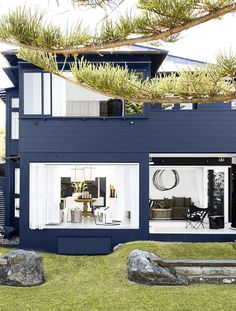 a modern house with large windows and plants on the roof