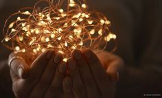 a woman holding out her hands with some lights on it