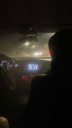 the interior of a car at night with lights on and fog in the air behind it