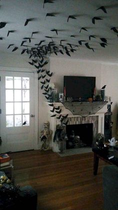 a living room filled with furniture and a fire place covered in birds flying over the fireplace