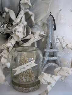 a glass jar filled with sand next to a silver eiffel tower