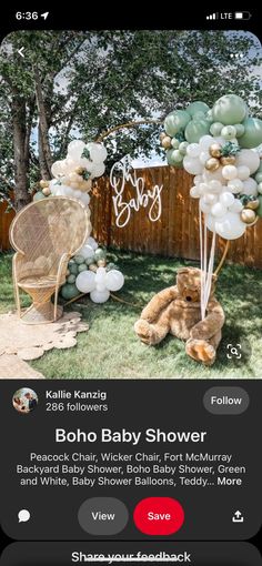 a baby shower with balloons and teddy bears on the grass in front of a fence