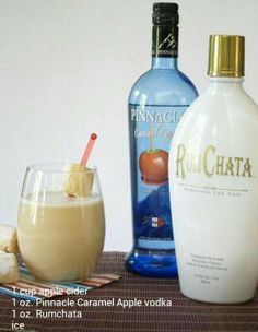 two bottles of rumchata next to a glass filled with ice and cinnamon sticks