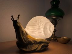 a snail lamp sitting on top of a wooden table