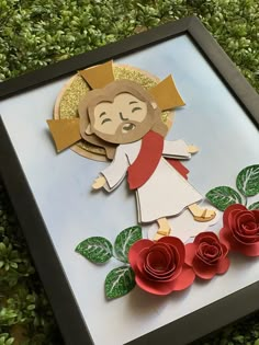 a paper cut out of jesus with roses in front of it on top of grass