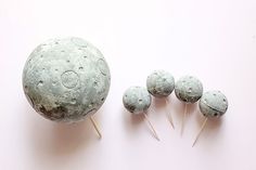 four round lollipops sitting next to each other on top of a pink surface