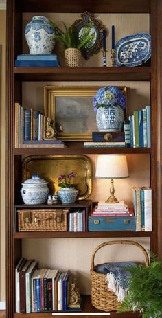 a bookshelf filled with lots of books and vases