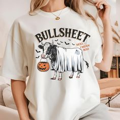 Comfort Colors® Ghost Cows Halloween Shirt, Funny Cow Halloween T-Shirt, Bullsheet Ghost Costume shirt, Ghost Shirt, Cow Lovers Halloween Gift, Halloween Ghost Cows Shirt, Halloween Animals, Fanny Halloween Get ready to bring the laughs this Halloween with this funny and punny cow-themed shirt! Featuring an adorable cow dressed as a ghost with a pumpkin bucket, this "Bullsheet" design is perfect for those who love clever wordplay and quirky costumes. Whether you're trick-or-treating, going to a Halloween party, or just love animals and humor, this shirt is sure to be a hit. Great for all ages, it's the ideal Halloween outfit for cow lovers, farmers, or anyone with a sense of humor. The "Moo... I Mean Boo" joke adds the perfect touch to this cute and spooky design. Grab yours today and cele Quirky Costumes, Cow Dress, Cow Halloween, Pumpkin Bucket, Ghost Costume, Funny Cow, Cow Shirt, Cows Funny, Spooky Designs