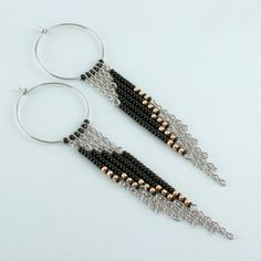 two pairs of black and gold beaded dangle earrings with silver hoop closures