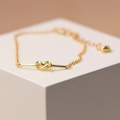 A beautiful gold filled trace chain winds into a knot that is the perfect symbol of a marriage ceremony. It will make a gorgeous accessory to the bride's wedding dress and is such an appropriate gift for a bridegroom to offer his bride on her wedding day or for her bridesmaids helping make the day special, what a lovey bridesmaid gift. The bracelet also features a 12mm gold plated over sterling silver pendant attached to the lobster clasp. We can engrave with up to 25 characters. Perhaps an initial, name, message for the bridesmaids or the wedding date for the bride? This gorgeous gift comes in a grey gift box. - Yellow gold filled - 17cm long with 20mm extender chain - Lobster clasp - Heart detail - Eco-friendly gift box Yellow Gold Recycled Gold Bracelet For Gift, Yellow Gold Recycled Gold Bracelet As A Gift, Gift Yellow Gold Bracelet In Recycled Gold, Gold-tone 14k Gold Chain Bracelet As Gift, 14k Gold-tone Chain Bracelet As Gift, Gift Tarnish Resistant Recycled Gold Bracelet, Tarnish Resistant Recycled Gold Bracelet Gift, Gold Chain Bracelet 14k Gift, Gold Chain Bracelet 14k As Gift