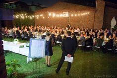 a man and woman standing next to each other in front of an audience at a dinner