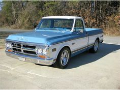 an older pickup truck parked in a parking lot