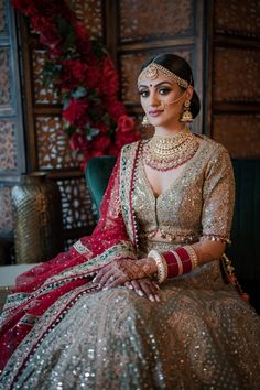 a woman in a bridal gown sitting on a couch with her hands clasped to her chest